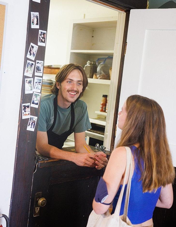 a student worker at the grove house takes a food order from another student